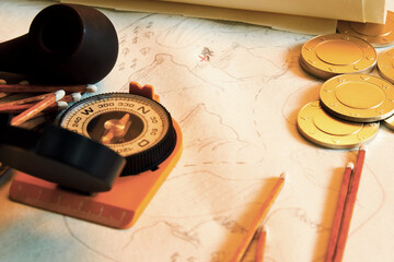 Vintage treasure hunting concept with map, gold coins, smoking pipe and compass. Retro pirates equip