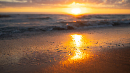 Fototapeta na wymiar Sonnenuntergang am Strand mit Lichtreflexion im Sand