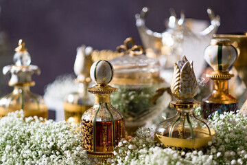 A variety of perfumes in decorative glass and crystal bottles on a table with Baby's Breath. Setup...