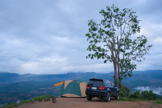 Camping with a Toyota Fortuner 4x4 and tent in a beautiful morning with fog on the mountains at Doi Mon Mak Campground is a campsite in Mae Chaem, Chiang Mai, Thailand.