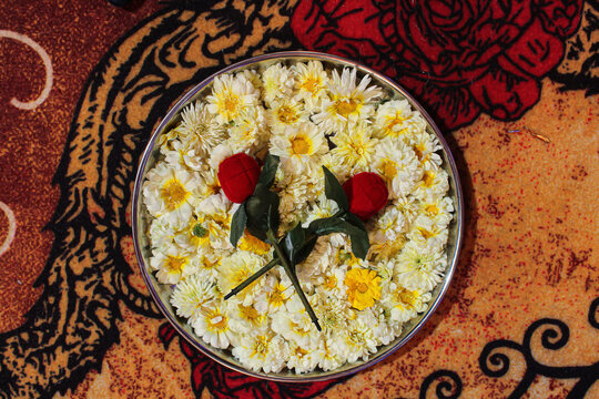 Stock photo of plate decorated with white color flowers , artificial red roses placed over the flowers for ring ceremony. Picture captured during ring ceremony occasion at Kolhapur, Maharashtra, India