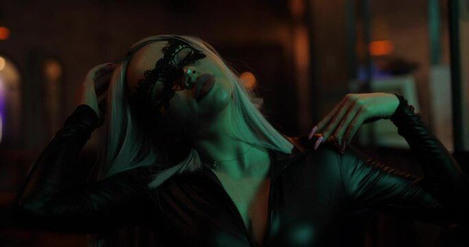Sexy frisky naughty woman with eyemask posing in the night bar