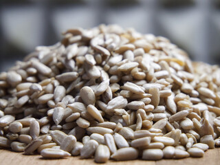 A pile of peeled sunflower seeds on a wooden surface, macro