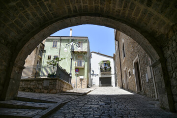 Fototapeta na wymiar A narrow street between the old houses of Pietragalla, a village in the Basilicata region, Italy.