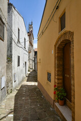A narrow street between the old houses of Pietragalla, a village in the Basilicata region, Italy.