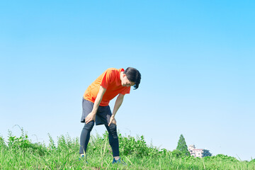 屋外で運動中に疲れる男性