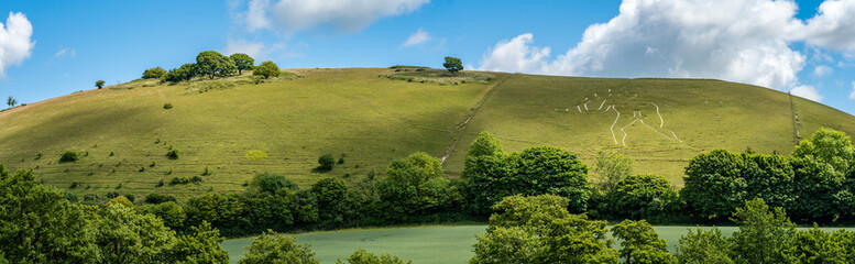 Panoramatic view of a hillside with The Cerne Abbas Giant, an ancient hill figure near the village...