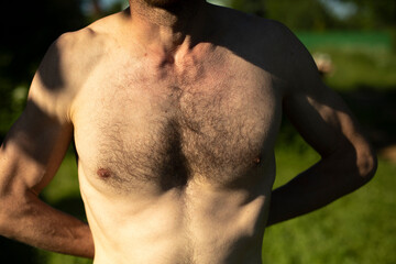 Hairy chest of man on beach. Guy's chest is in sunlight. Body details.