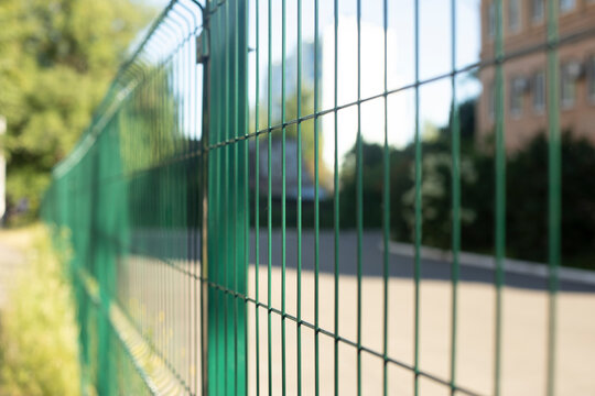 Fence made of steel bars. Fence made of netting in parking lot. Steel mesh.