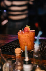 Special drink with passion fruit and strawberry ready to be served to the customer at the bar counter