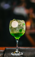 Cocktail with cherry and green apple served with Gin in pub bar