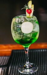 Cocktail with cherry and green apple served with Gin
