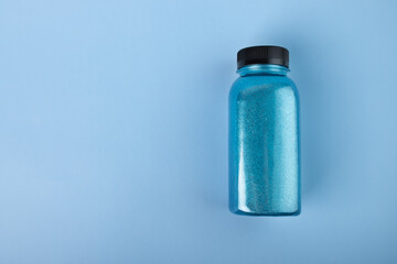 shimmering bath salt in bottle, shiny blue cosmetics, bright cosmic sparkles, copy space