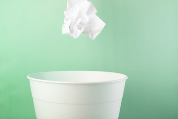 paper waste recycling, environmental protection, ecology development, renewable, crumpled sheet of paper flies into the trash can