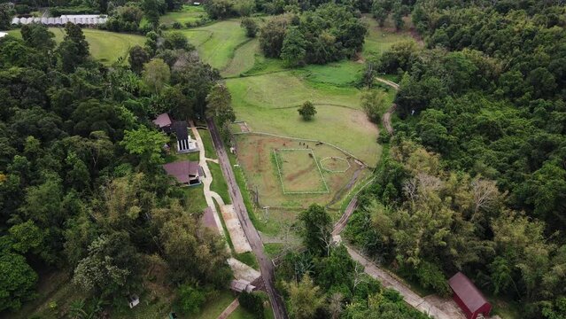 Aerial bird's eye view of cottages along the mountain slope in Tham Pla Pha Suea National Park, nothern Thailand at daytime. Pang Tong Royal Project.