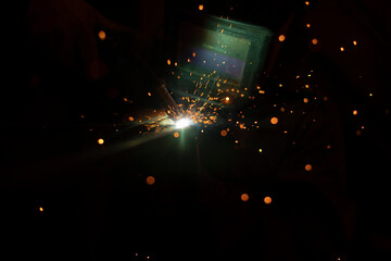 Welding work. Sparks from welding metal. Production details.