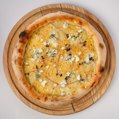 Top view of hot pizza on a wooden stand.