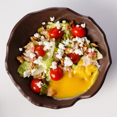 Salad with bacon, feta french fries with sausages in cheese sauce.