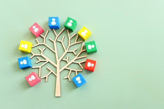 Business image of wooden tree with people icons over green background, human resources and management concept