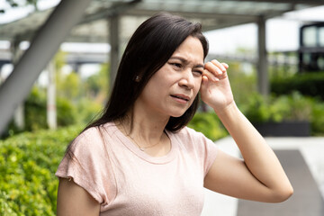 Fototapeta premium Tired middle aged woman suffering from strong sunlight, hot weather and heat wave