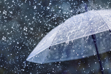 Transparent umbrella under heavy rain against water drops splash background. Rainy weather concept. - obrazy, fototapety, plakaty