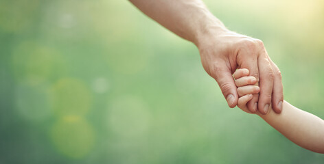 Fathers hand holding his little child in sunny day outdoor, united family and happy childhood...