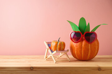 Creative home decoration for Halloween holiday celebration. Pumpkin as pineapple with sunglasses on...