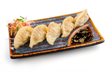 Gyoza or dumplings snack with soy sauce and vegetable on plate isolated on white background