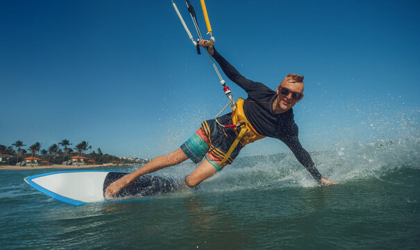 Kite surfer riding a kiteboard on the sea with splash