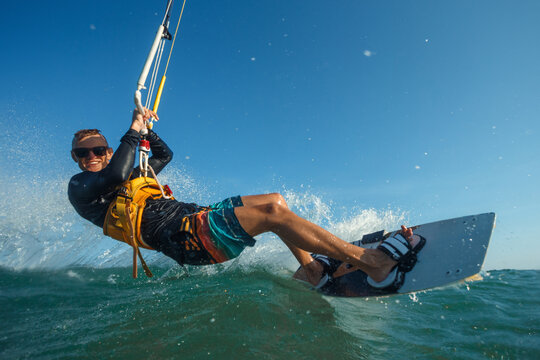 Kite surfer riding a kiteboard on the sea with splash