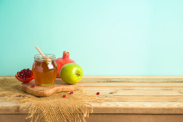 Jewish holiday Rosh Hashana background with honey, apple and pomegranate on wooden table