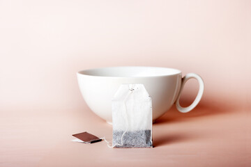 tea bag on white ceramic cup background, copy space, selective focus