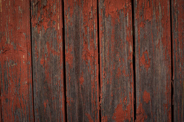 Old natural weathered wooden planks with cracked red paint background