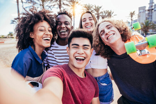 Multiracial friends taking selfie outside on summer vacation - Young people having fun hanging out on a sunny day - Youth, friendship and summer vacation concept