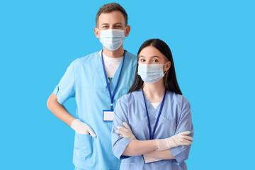 Medical assistants in protective masks on blue background