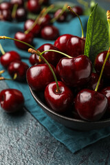 Obraz na płótnie Canvas Bowl of ripe cherries on dark color background, closeup