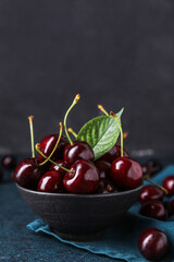 Bowl of ripe cherry on dark background