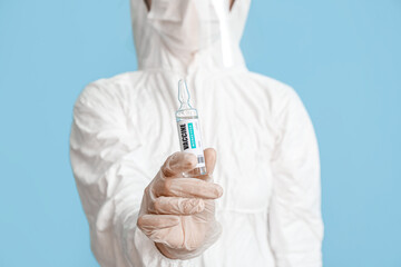 Scientist with monkeypox vaccine on blue background