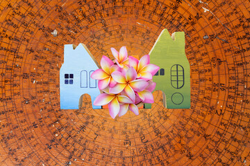 Wooden house with flower on feng Shui compass plate background