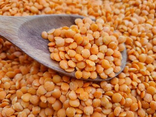 Orange lentils, also known as Syrian lentils, with a wooden spoon.