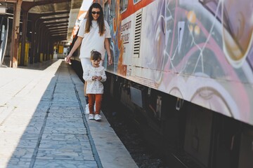 mother with her child in love is walking on the railway station in varna bulgaria 
