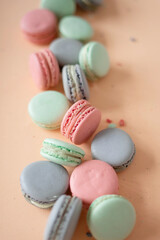Pink, green and lilac macarons cookies on a pink background.