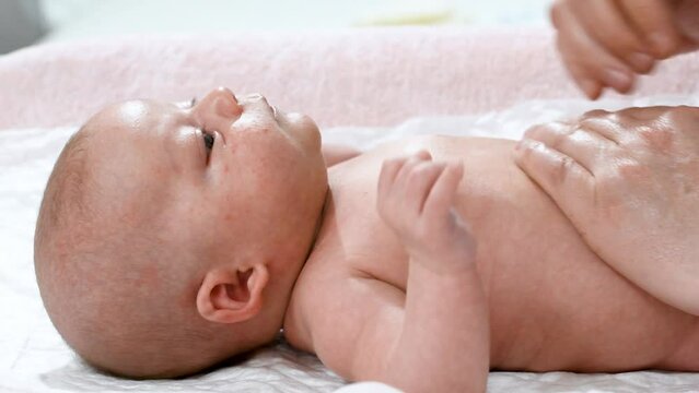 4k video of the hands of a pediatric physiotherapist performing a massage on the tummy and abdomen of a newborn baby to treat, calm and prevent infant colic