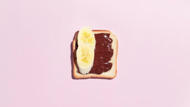 Set of toasted bread with peach, apple and banana on pink background. Stop Motion Animation. Top view.