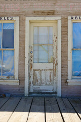 shabby front door to abandoned building in ghost town