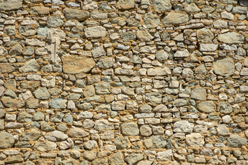Ancient stonewall with irregular pattern and grungy atmosphere from house in Carpentras, France