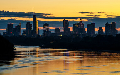 Warsaw skyline during orange sunset, The line of skyscrapers black silhouettes.
