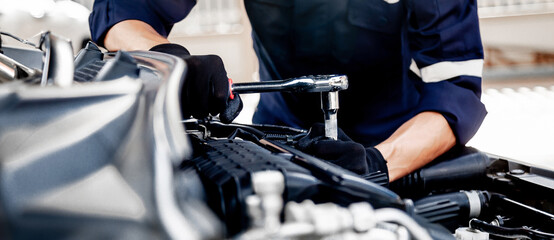 Car care maintenance and servicing, Close-up hand technician auto mechanic using the wrench to...