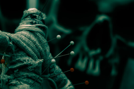 curse doll in hand and skull background