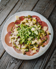 Plato gourmet de carpaccio de ternera con rucula y parmesano